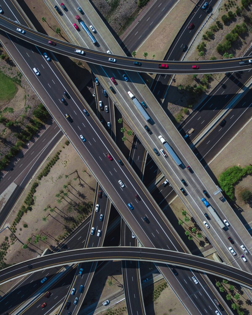 Overhead drone shot of a busy highway intersection full of traffic during daytime