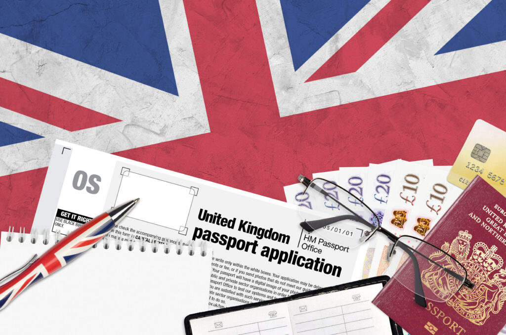 English form OS United Kingdom passport application from HM passport office lies on table with office items. UK passport paperwork